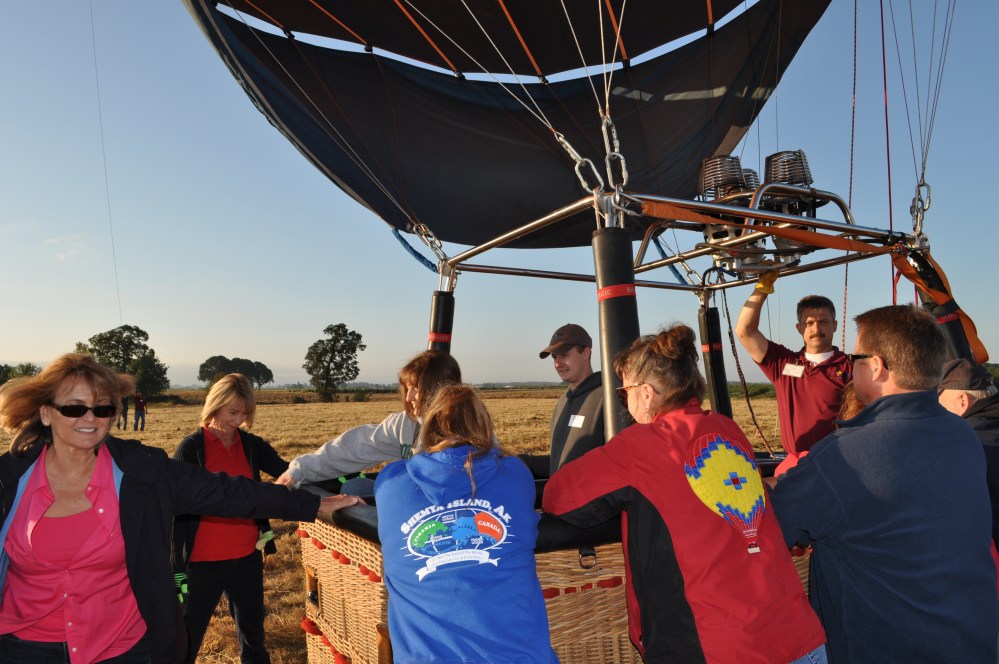 Both crew and passengers hold the basket down while people climb out.