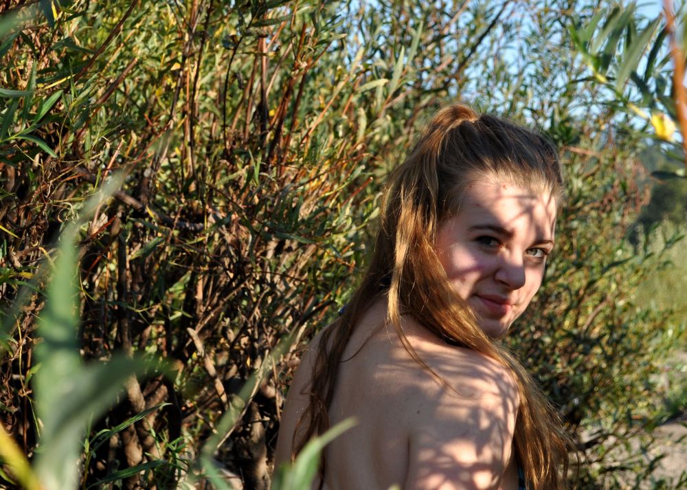 My pretty girl in the bushes, seeking out shade to do her homework in between splashes.