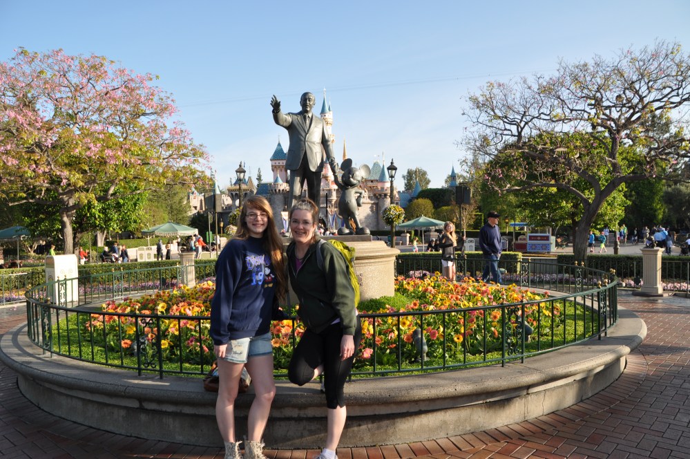 Tara and I stand with Mickey and Walt, in front of the iconic Disney castle.