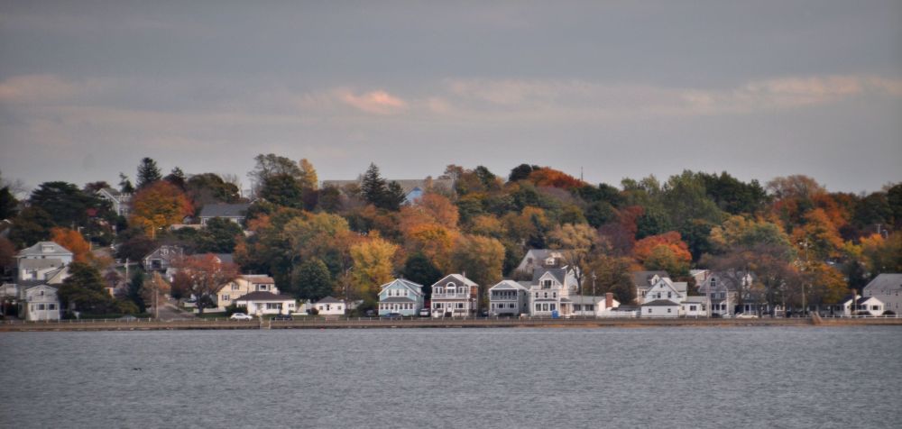 New England homes and foliage across the bay.