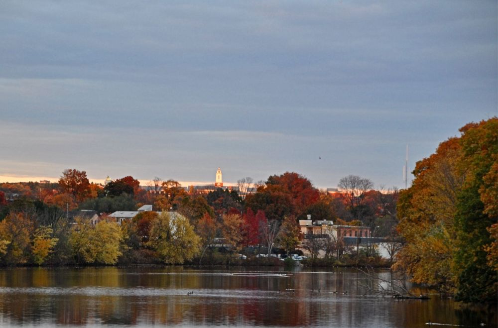 Illuminated white tower at sunset and brilliant foliage reflected in the water. Some scenes are inescapably New England.