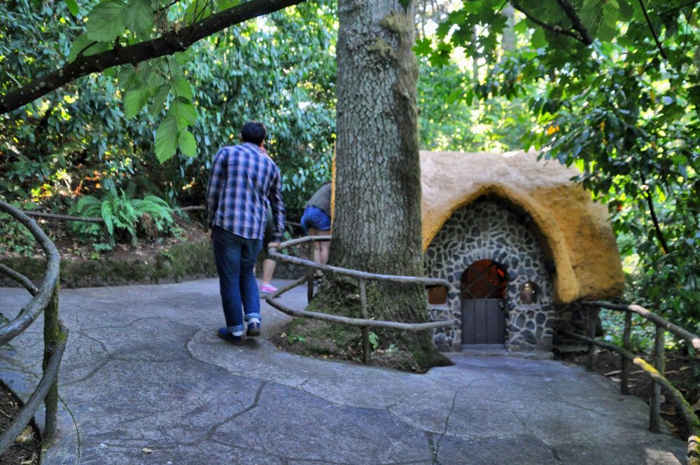 The kids peek into the windows of the tiny house of the Seven Dwarves.