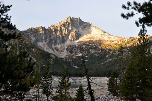 The north side of McClellan Peak lights up in the morning sunshine above Upper Snow Lake.