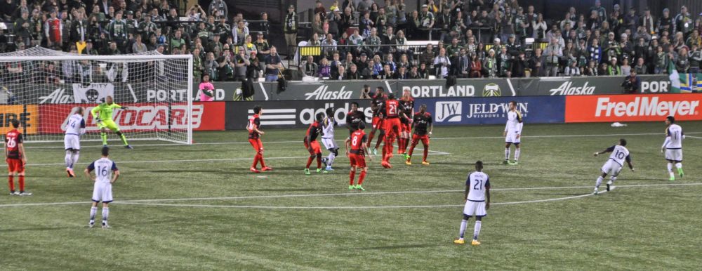 Ball is in the air (a white smudge above the A in Alaska) and Timbers goalie has his eye on it.