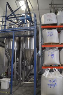 The polished rice is then piped to this station, next to 2-ton bags of rice.